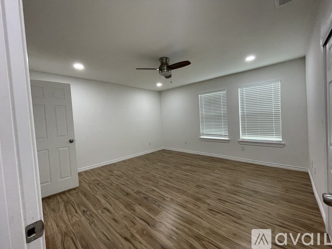A room with wooden flooring and a ceiling fan.