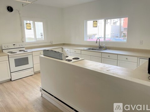 A kitchen with white appliances and cabinets is available for rent.