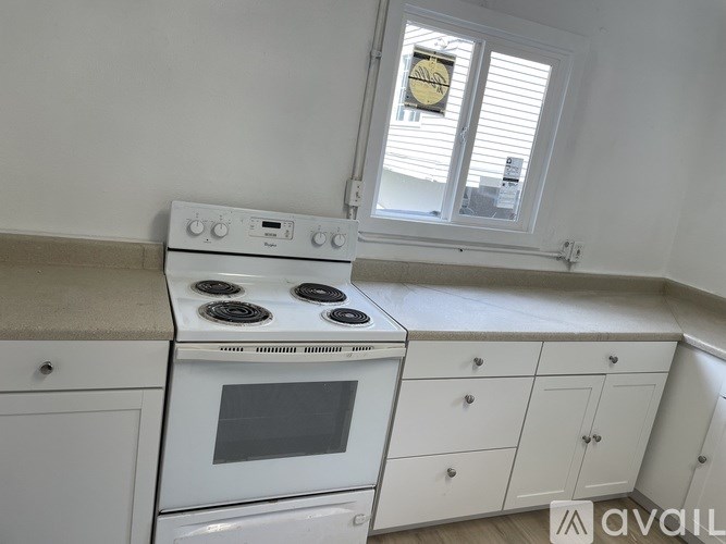 A white kitchen with a stove and cabinets.