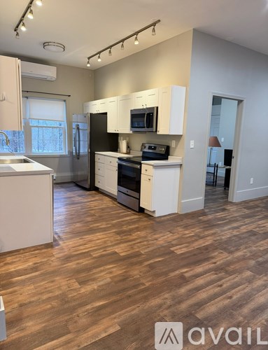 A kitchen with wooden floors and white appliances.