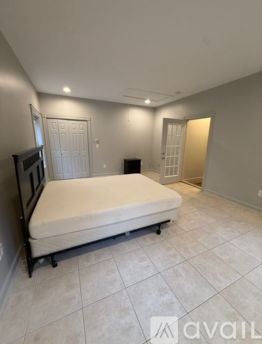 A bedroom with a bed, dresser, and mirror.