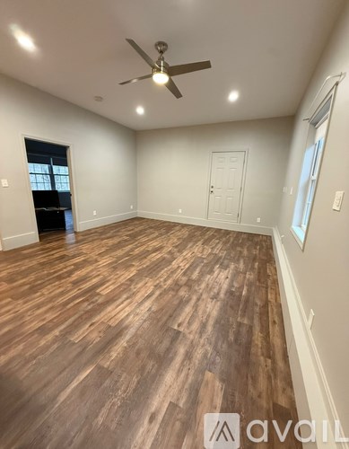 A room with wooden flooring and a ceiling fan.