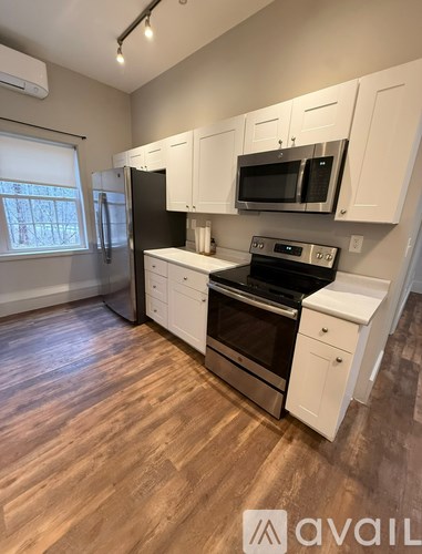 A kitchen with white cabinets and stainless steel appliances.