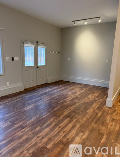 A room with wooden flooring and a door with a window.