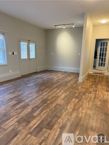 A room with wooden flooring and a window.