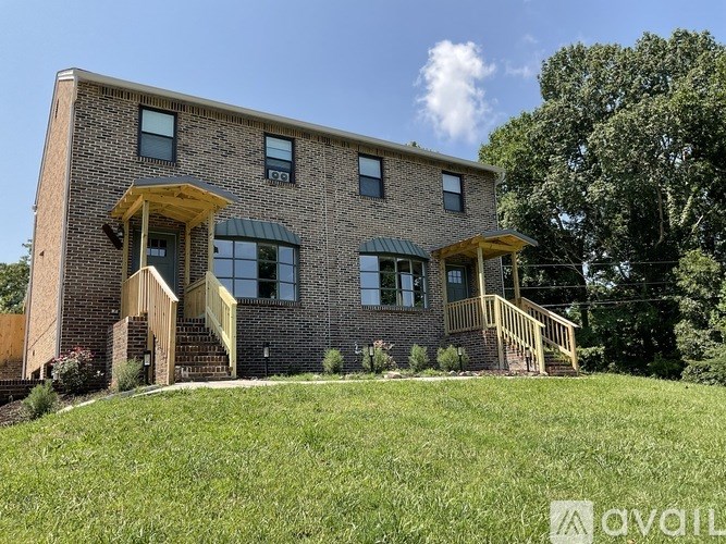 A brick house with a green lawn in front.