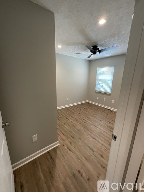 A room with wooden flooring and a ceiling fan.