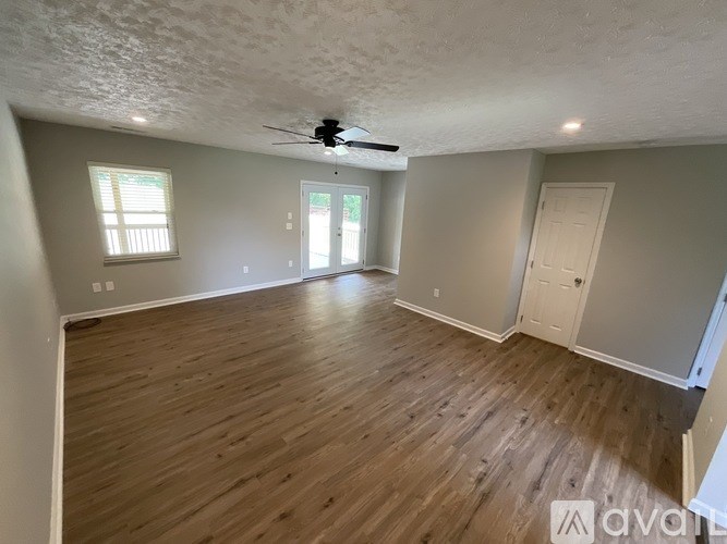 A room with wooden flooring and a ceiling fan.