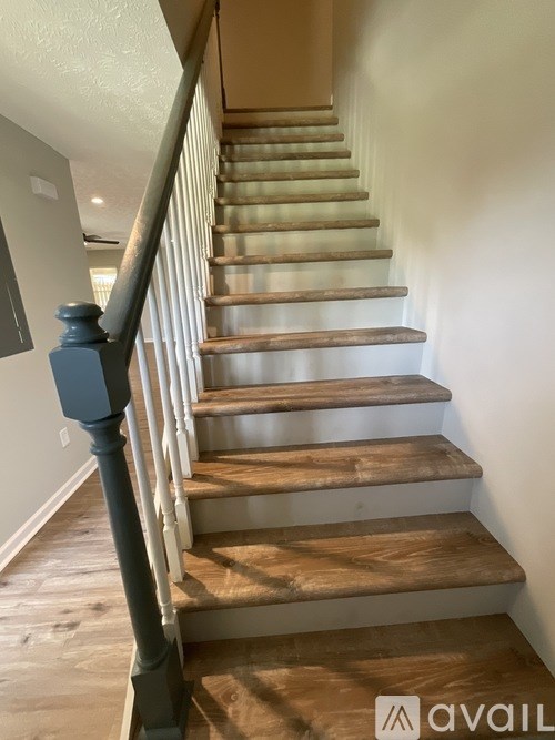 A staircase with wooden steps and a dark blue railing.