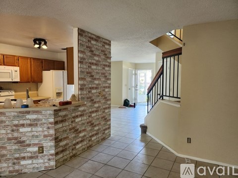 A kitchen with a brick wall and a staircase.