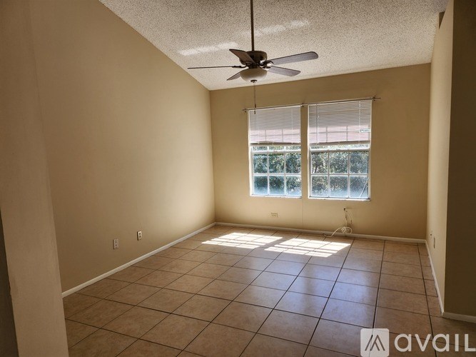 A room with a ceiling fan and tiled floor.