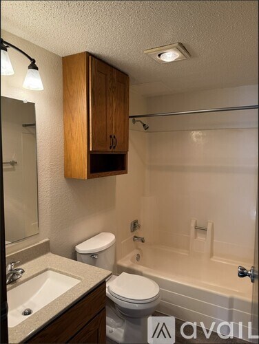 A bathroom with a toilet, sink, and bathtub.