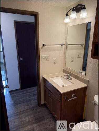 A bathroom with a sink, mirror, and toilet.