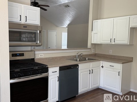A kitchen with white cabinets and a black stove top oven.