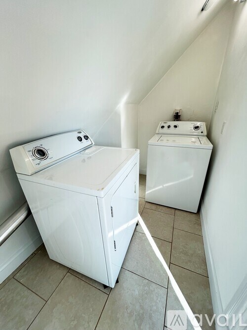 A white washing machine and dryer in a small laundry room.
