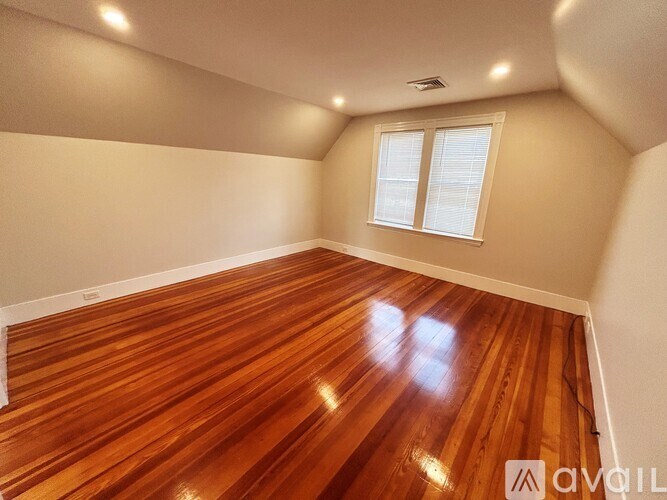 A room with wooden flooring and a window.