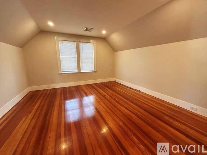 A room with wooden flooring and a window.