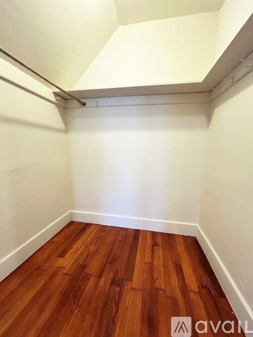 A room with wooden flooring and white walls.