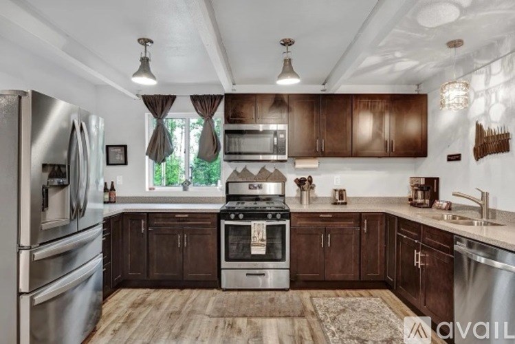 A kitchen with wooden cabinets and a stainless steel refrigerator.