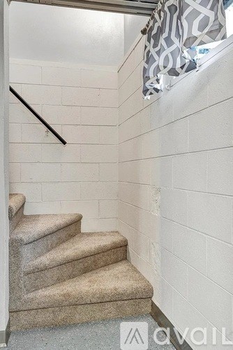 A staircase with a carpeted runner and a metal handrail.