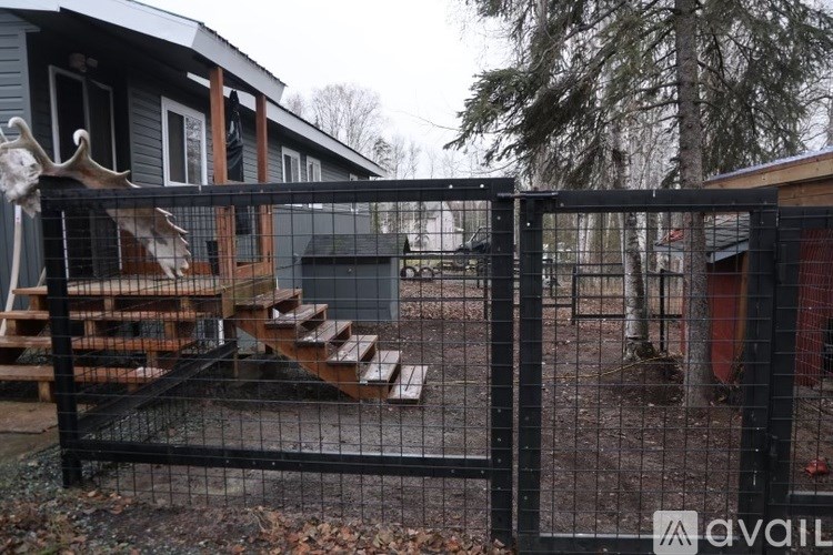 A house with a black fence and a deer head mounted on it.