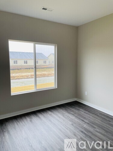 A room with a large window overlooking a field.