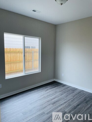 A room with a window and wooden flooring.