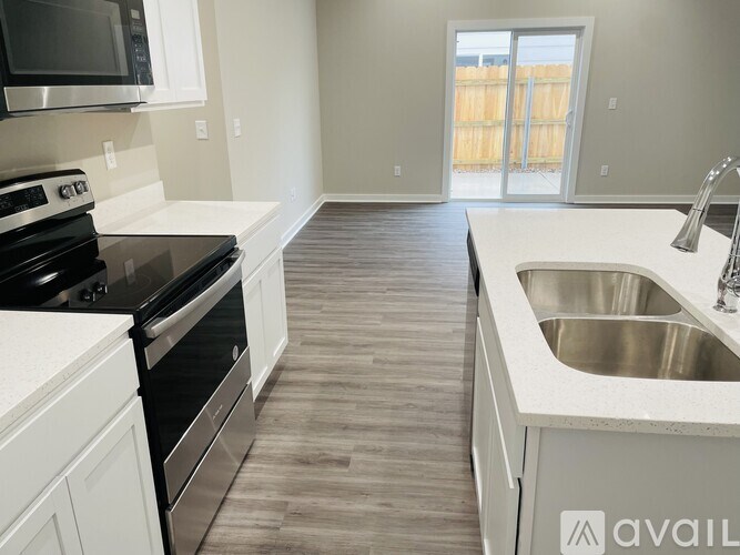A kitchen with a stove top oven, microwave, and sink.