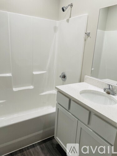 A white bathroom with a sink and a bathtub.