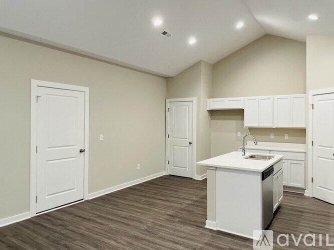 A kitchen area with a sink, cabinets, and a countertop.