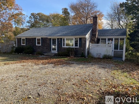 A small house with a white fence in front of it.