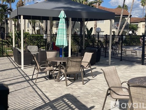 A patio with chairs and a table under a canopy.