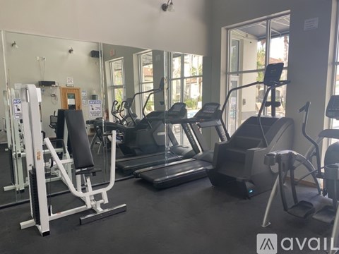 A gym with a variety of equipment including treadmills, weights, and exercise machines.