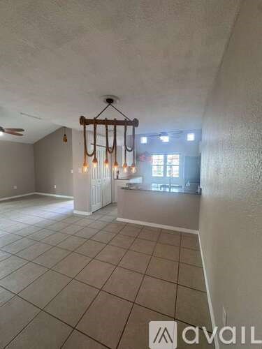 A room with a chandelier and a window.