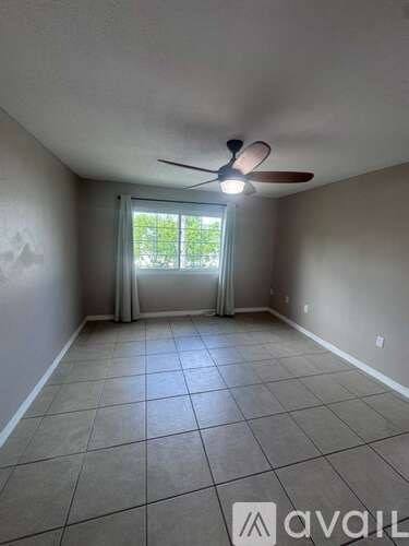A room with a fan and a sliding glass door leading outside.