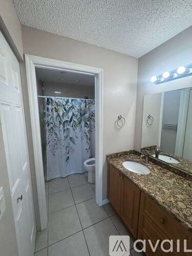 A bathroom with granite countertops and a walk-in shower.