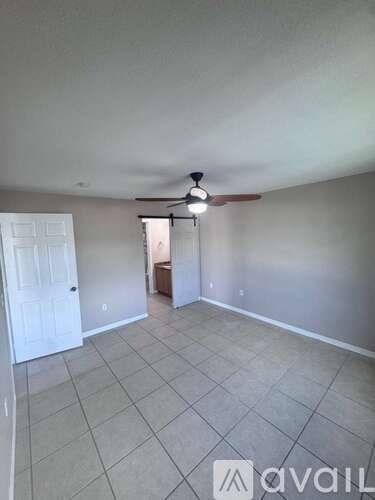 A room with a fan and a door is available for rent.