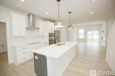 A modern kitchen with white countertops and stainless steel appliances.
