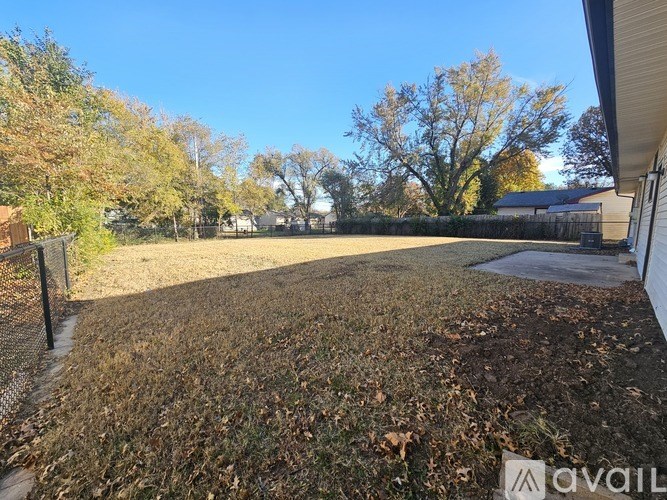 A backyard with a fence and trees.