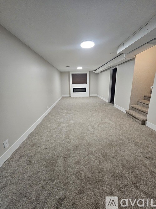 A long, empty hallway with a carpeted floor and white walls.