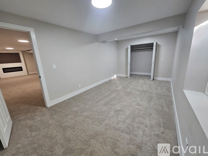 A spacious room with a carpeted floor and a white wall.