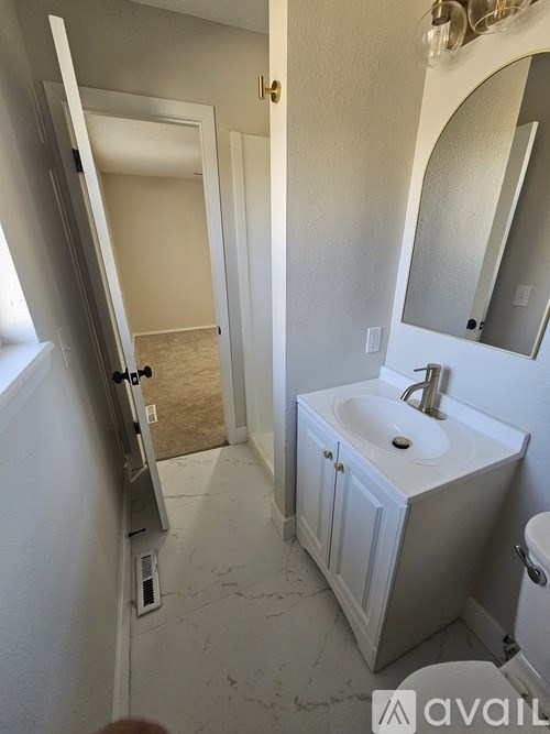 A bathroom with a sink, mirror, and toilet.