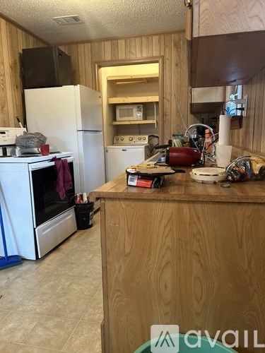 A kitchen with wooden cabinets and a white fridge.