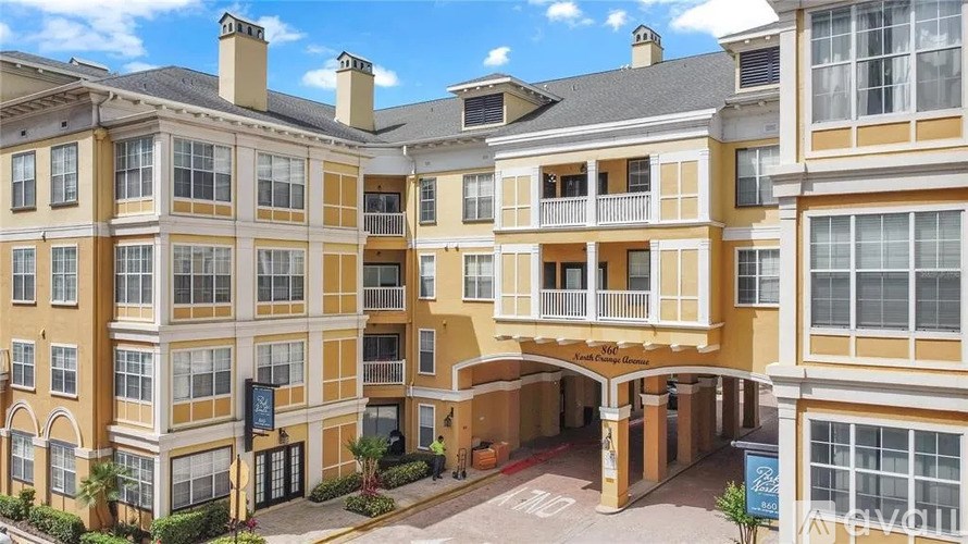 A large, multi-story building with a balcony and a sign that says "Ascot".