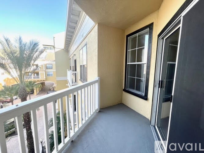 A balcony with a view of a building and palm trees.