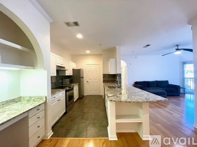 A kitchen with granite countertops and a ceiling fan.