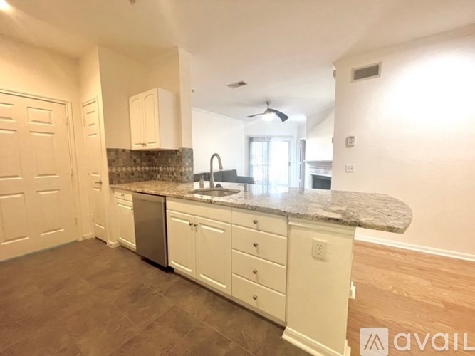 A kitchen with white cabinets and a granite countertop.