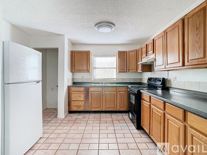 A kitchen with wooden cabinets and a white refrigerator.