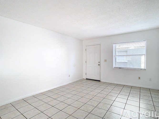 A room with white walls, a door, and a window with a white frame.