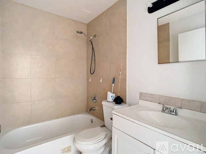 A bathroom with a white tub, toilet, and sink.
